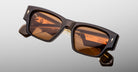 Jacques Marie Mage Zimmerman sunglasses in London brown acetate with bold rectangular frame, brown tinted lenses, and signature arrowhead front pins, angled front view