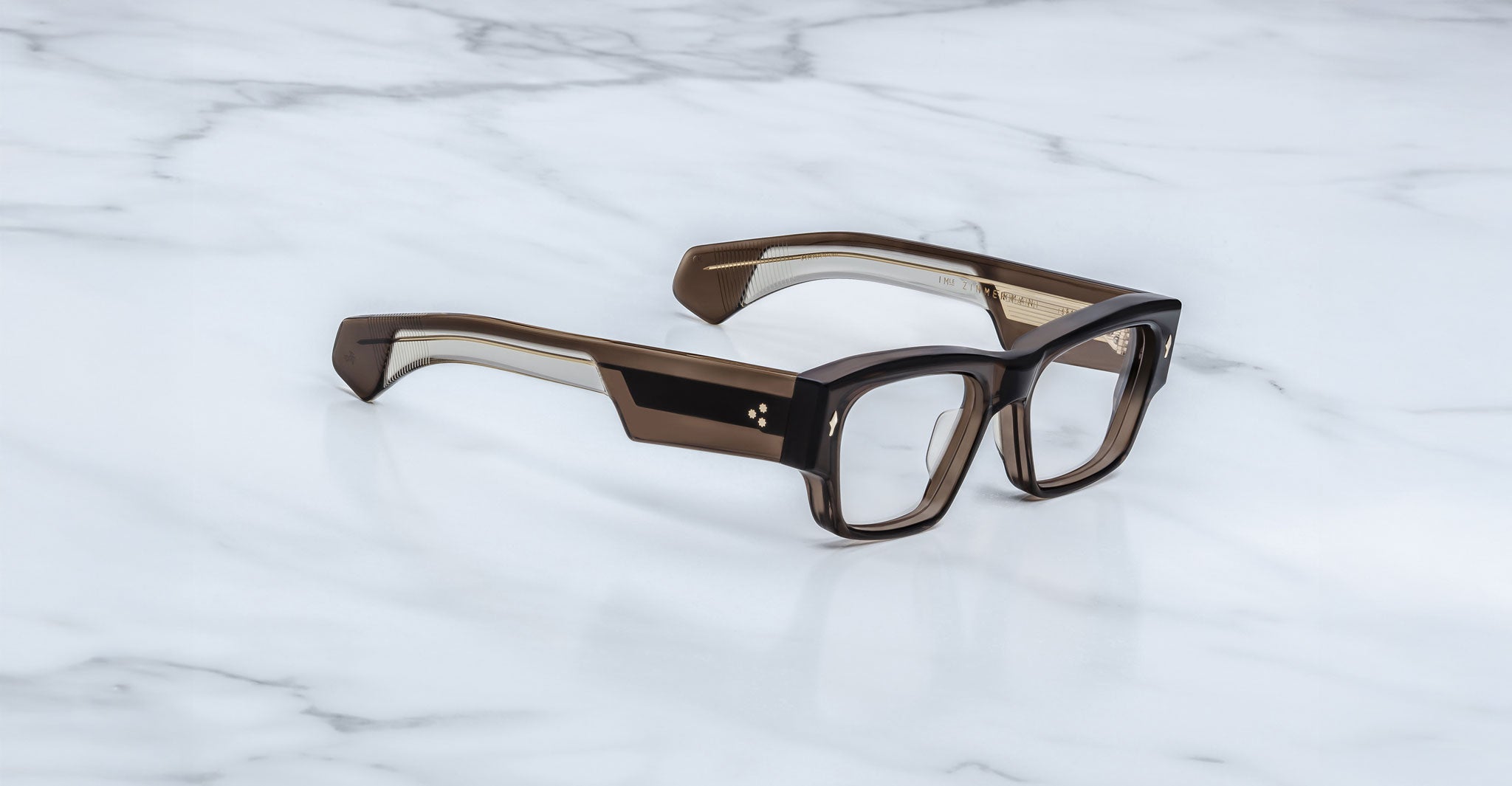 Jacques Marie Mage Zimmerman optical glasses in London brown acetate with bold rectangular frame, clear lenses, and wide temples with signature metal core detail, angled view