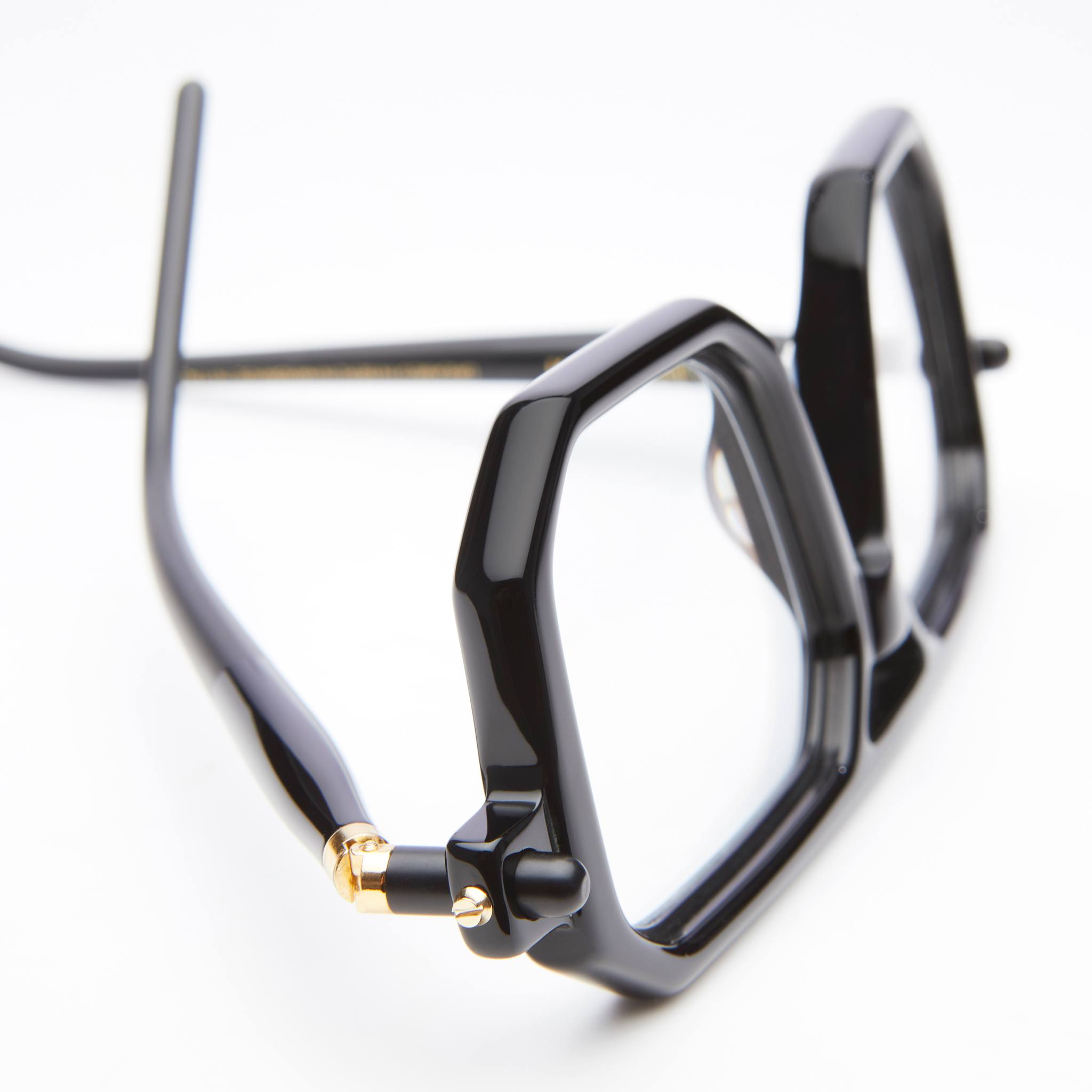 Kuboraum P8 eyeglasses in black with geometric frames and gold hinges, close-up front angle.