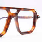 Close-up of KUBORAUM P8 brown geometric eyeglass frames with size markings, showing lightweight design from a front angle.