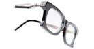 Close-up of Kuboraum D75 black square eyeglasses with clear lenses, silver metal hinge, and decorative temple detail, shown at an angle on a white background.