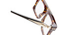 Close-up of Kuboraum D76 round eyeglasses with tortoiseshell frames and gold temple accent, front angle view.