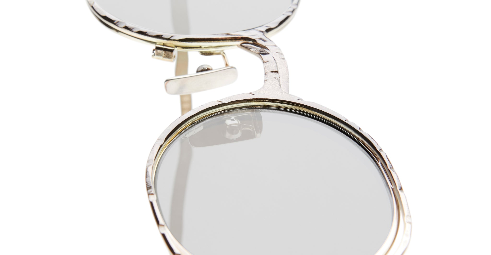 Close-up of Kuboraum H11 round silver-framed eyeglasses with clear lenses, highlighting the bridge and frame details against a white background.