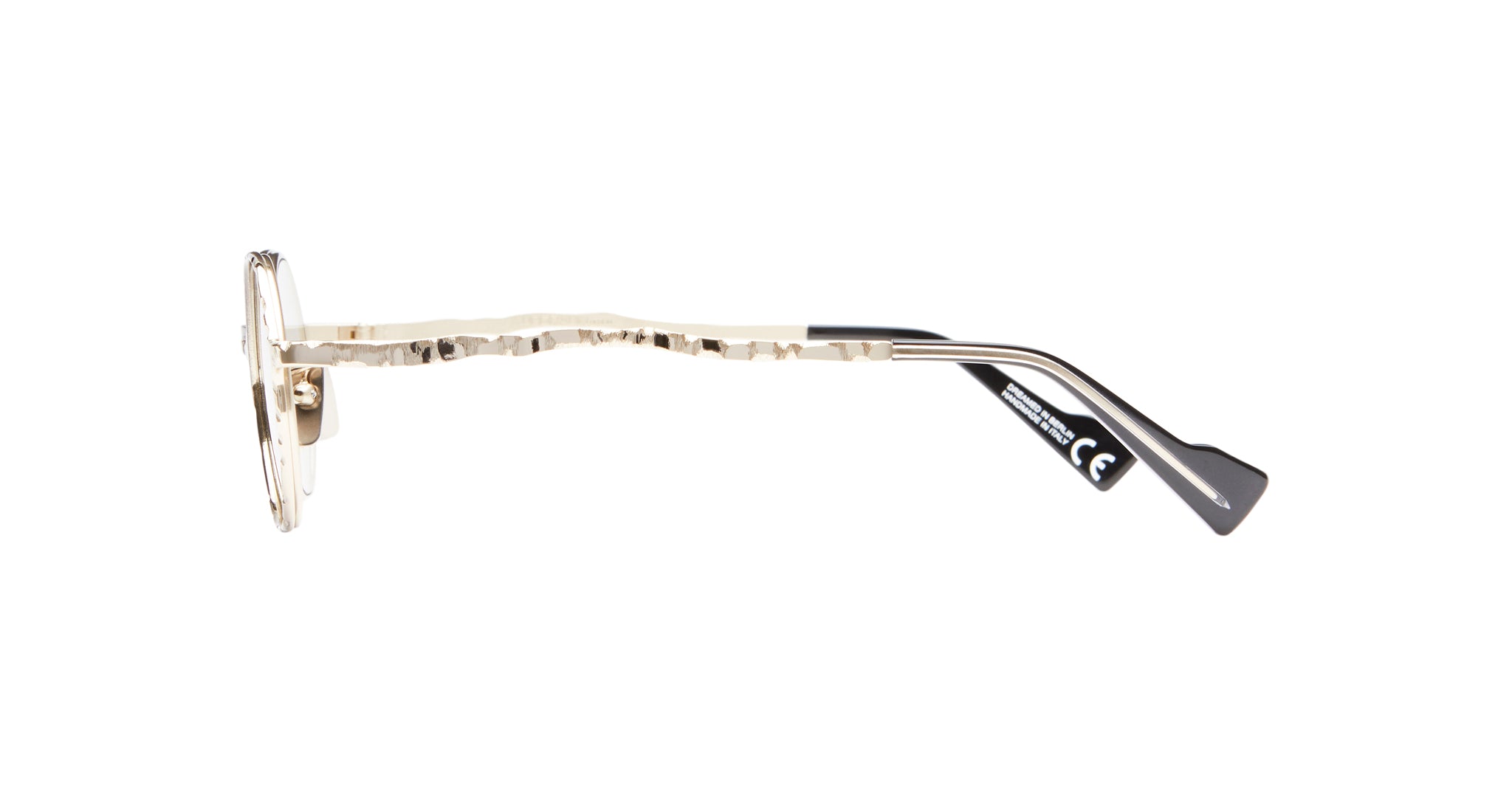 Side view of Kuboraum H11 gold metal eyeglass frames featuring hammered arm texture and black plastic temple tips, set against a white background.