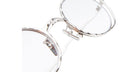 Close-up of Kuboraum H11 round silver metal eyeglasses with clear lenses, highlighting the detailed frame texture and adjustable nose pads. The mostly white background emphasizes the right half of the glasses.