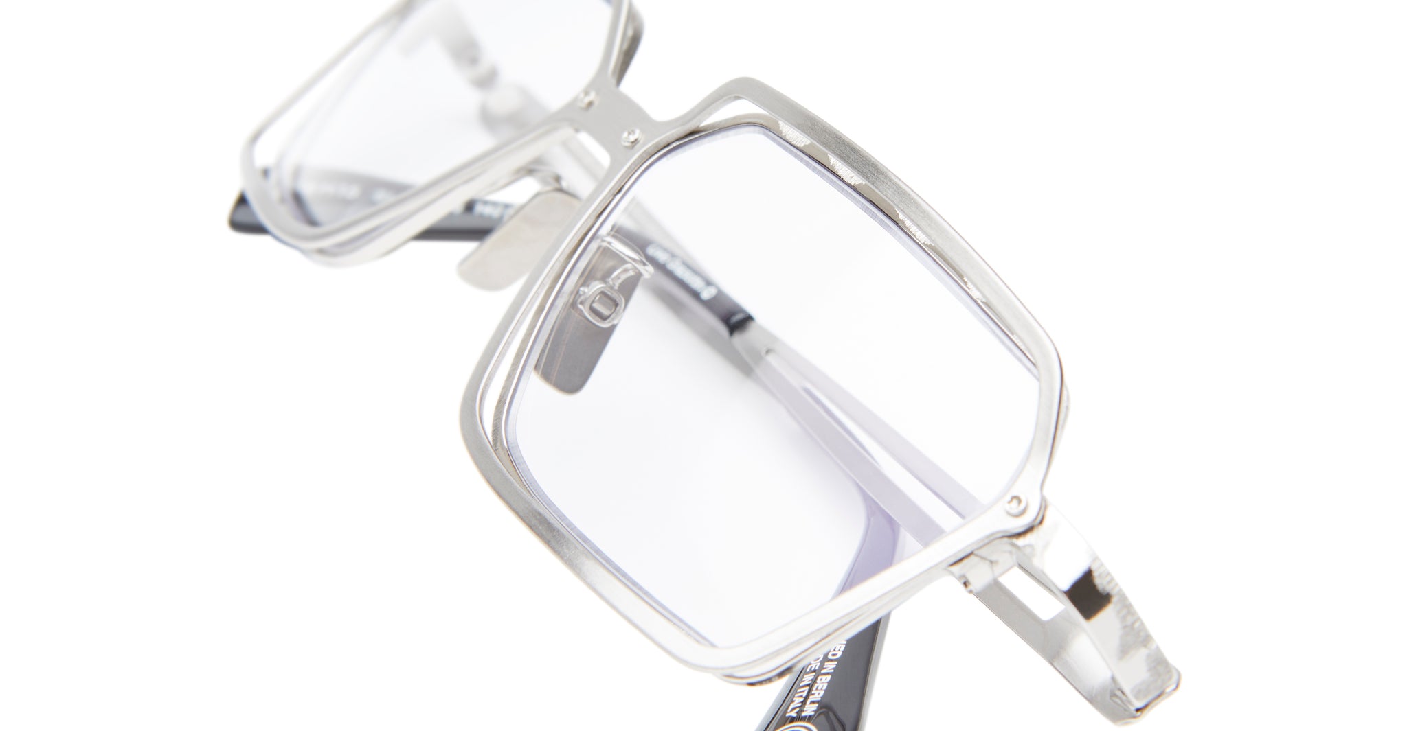 The Kuboraum H15 is a pair of eyeglasses featuring large, square, silver metal frames and clear lenses, displayed in a close-up view against a white background.