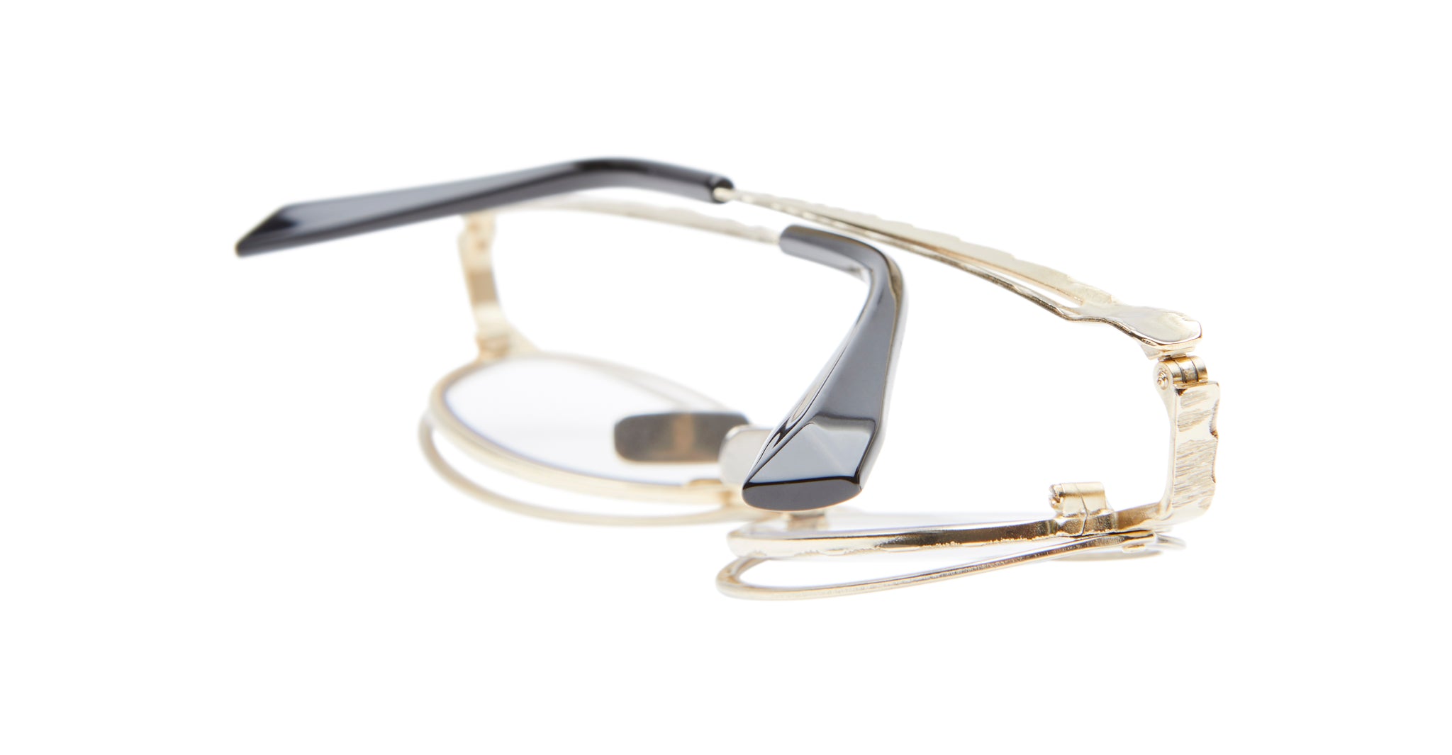 A pair of Kuboraum H18 eyeglasses featuring gold metal frames and black arms, folded on a white background.