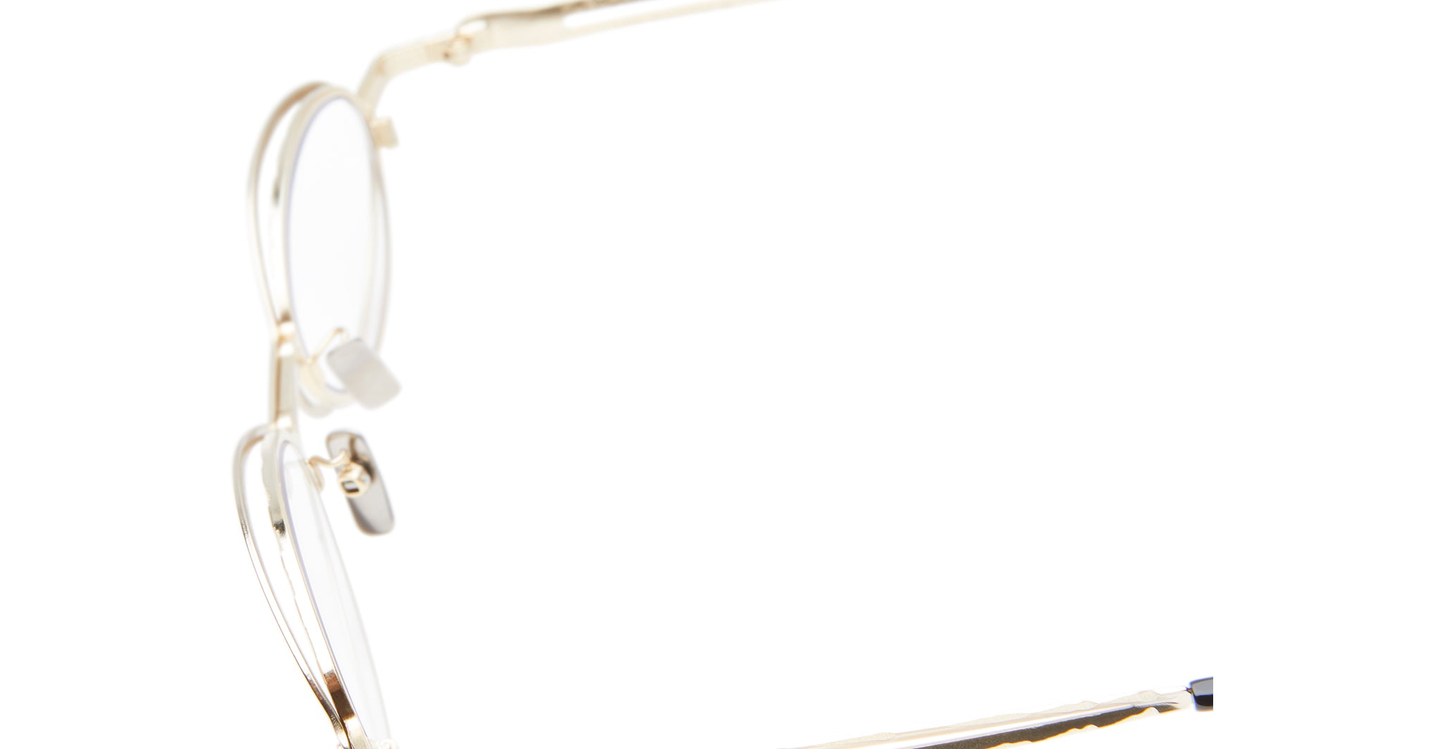 A close-up side view of the Kuboraum H18 gold-rimmed eyeglasses with clear nose pads, displayed against a white background.