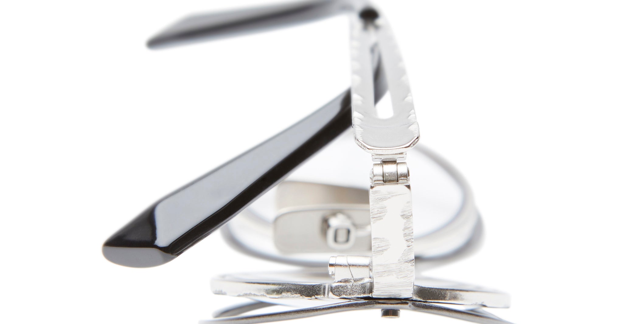 Close-up of the Kuboraum H18 eyelash curler with silver metal, black handles, and a silicone pad, shown vertically against a white background highlighting its detailed hinge design.