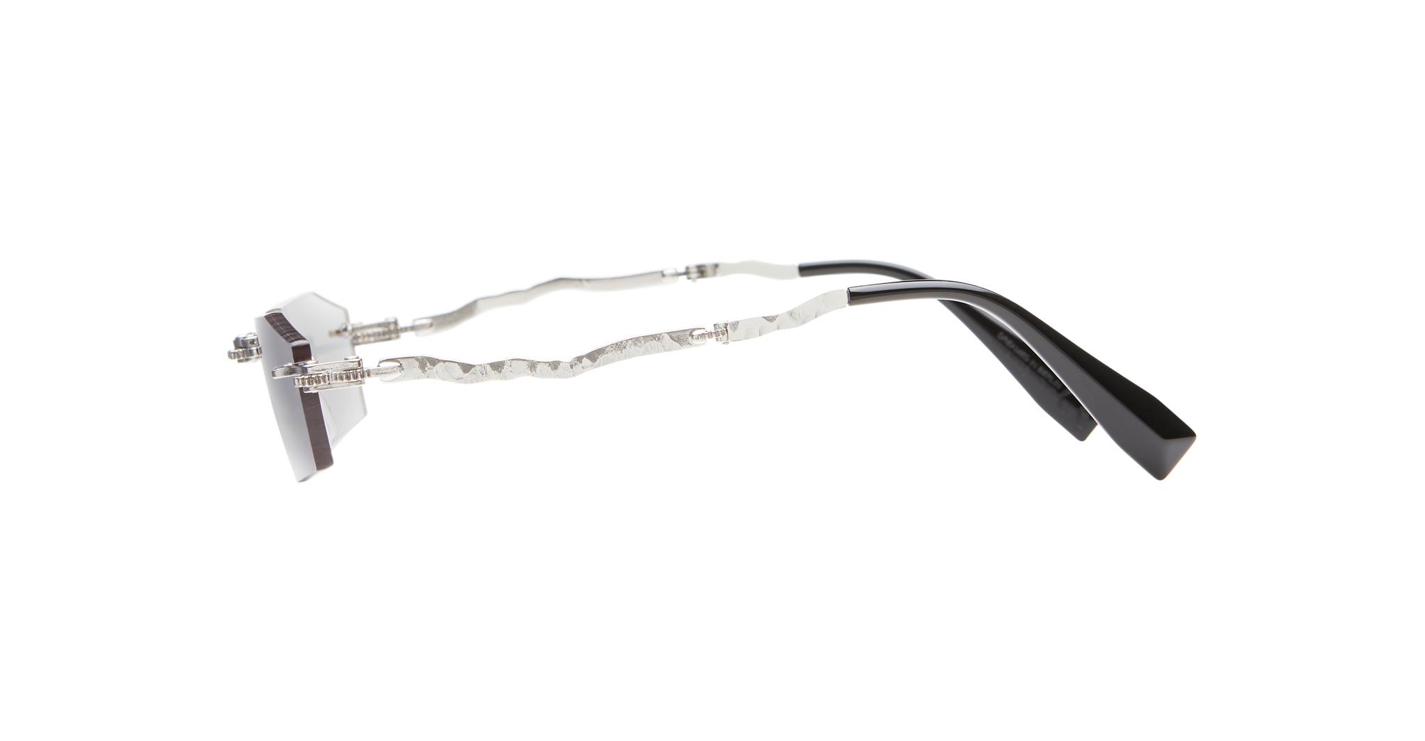 The Kuboraum H40 features geometric, angular lenses, wavy silver metal arms, and black acetate temple tips, displayed on a white background.
