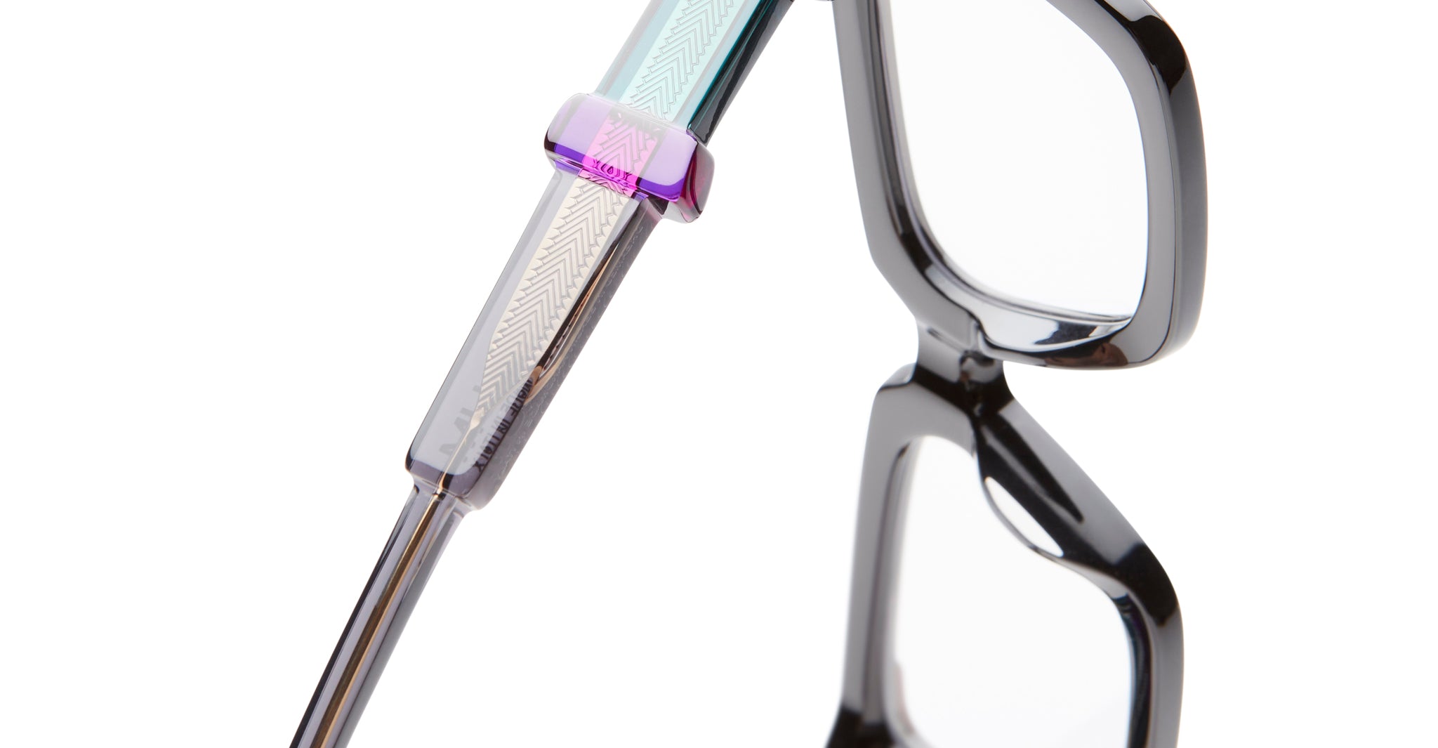 Close-up view of KUBORAUM Kuboraum I01 black eyeglasses hinge and arm, featuring patterned translucent acetate.