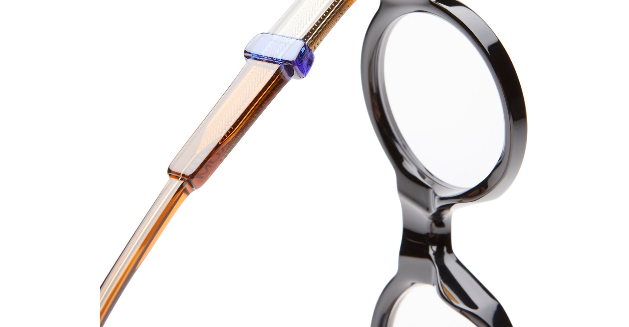 Close-up of Kuboraum I02 eyeglasses by KUBORAUM, featuring black round frames, brown and clear acetate temples, and blue accent.