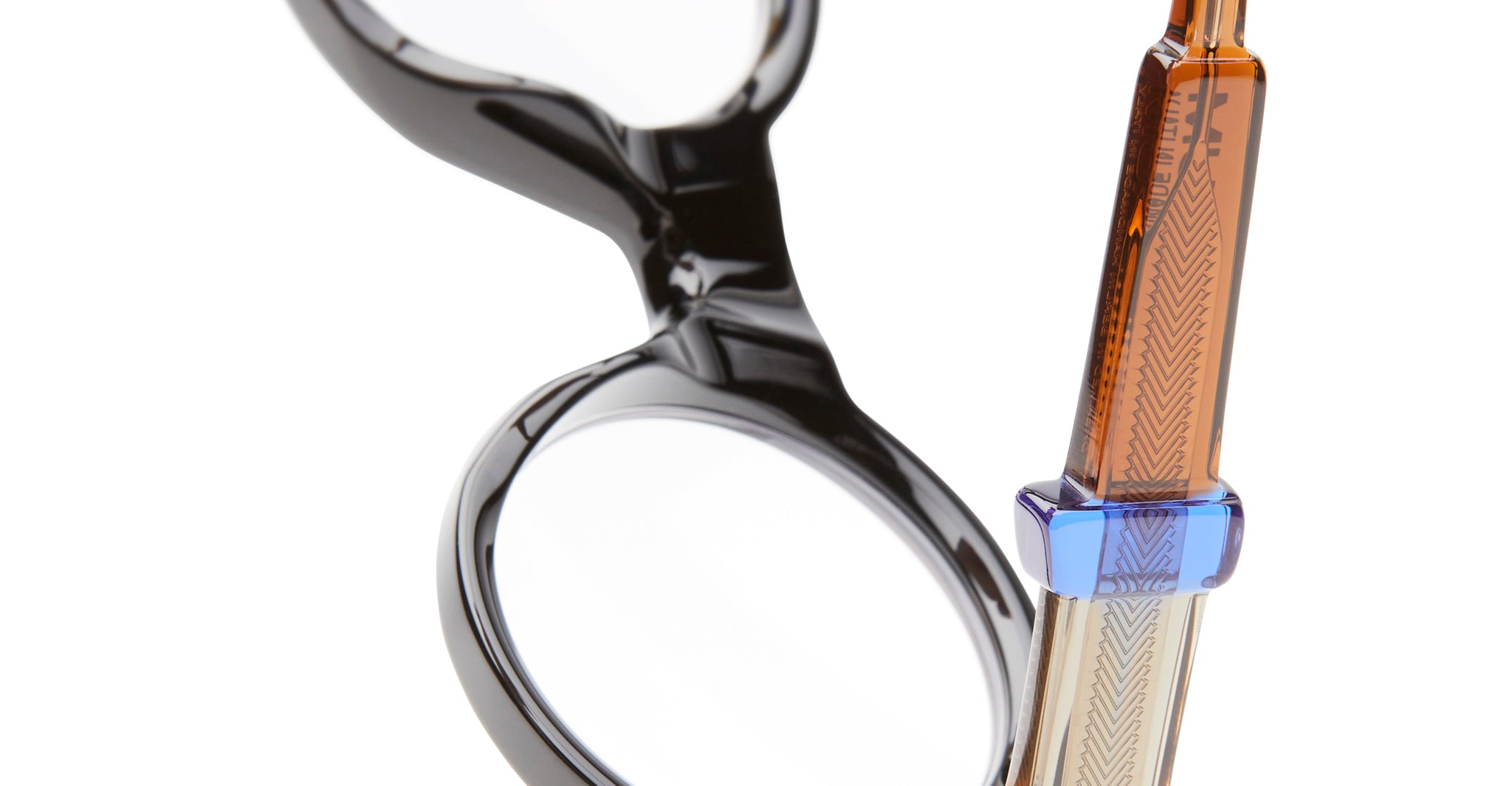 Close-up of KUBORAUM I02 eyeglasses, round black frames with amber and blue temple accents, brand and model visible front view.