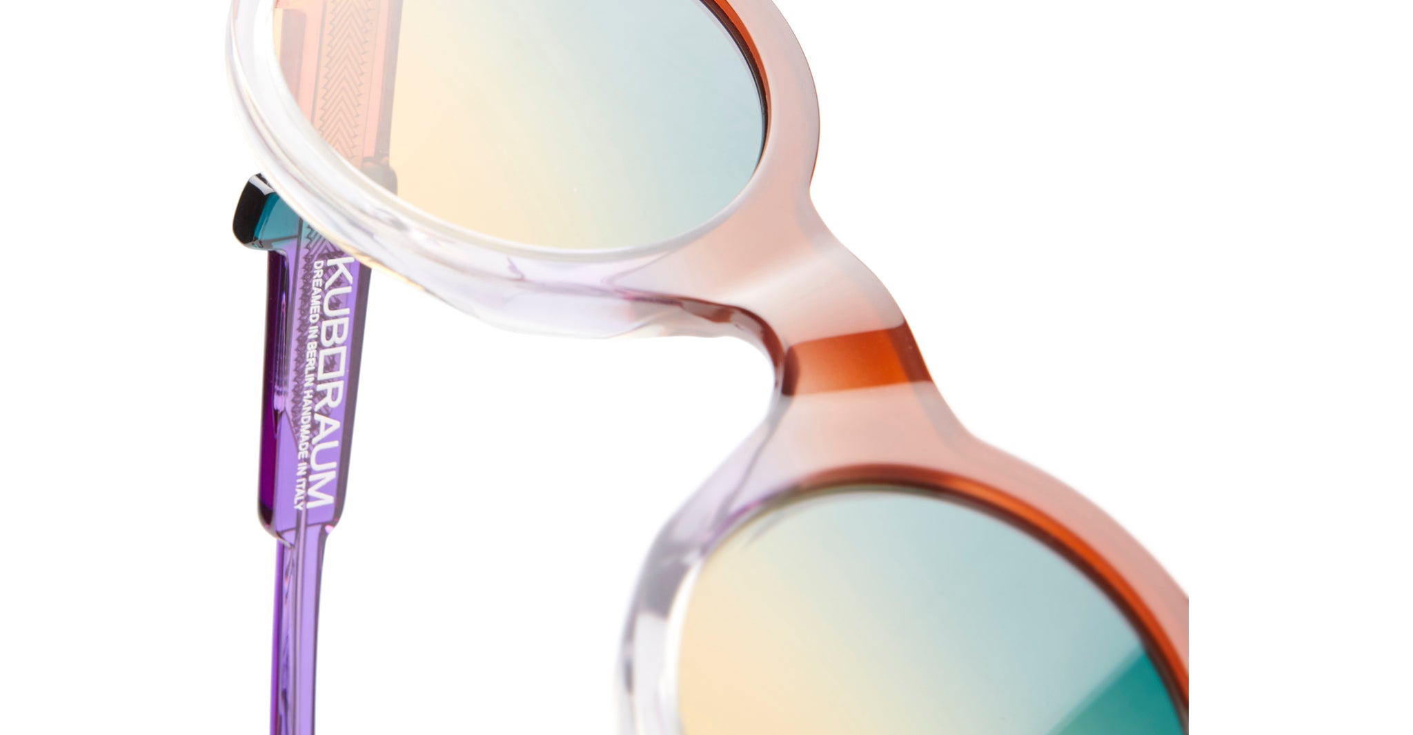 Close-up of Kuboraum I02 round sunglasses featuring gradient lenses, multicolored frames, and KUBORAUM logo on the temple.