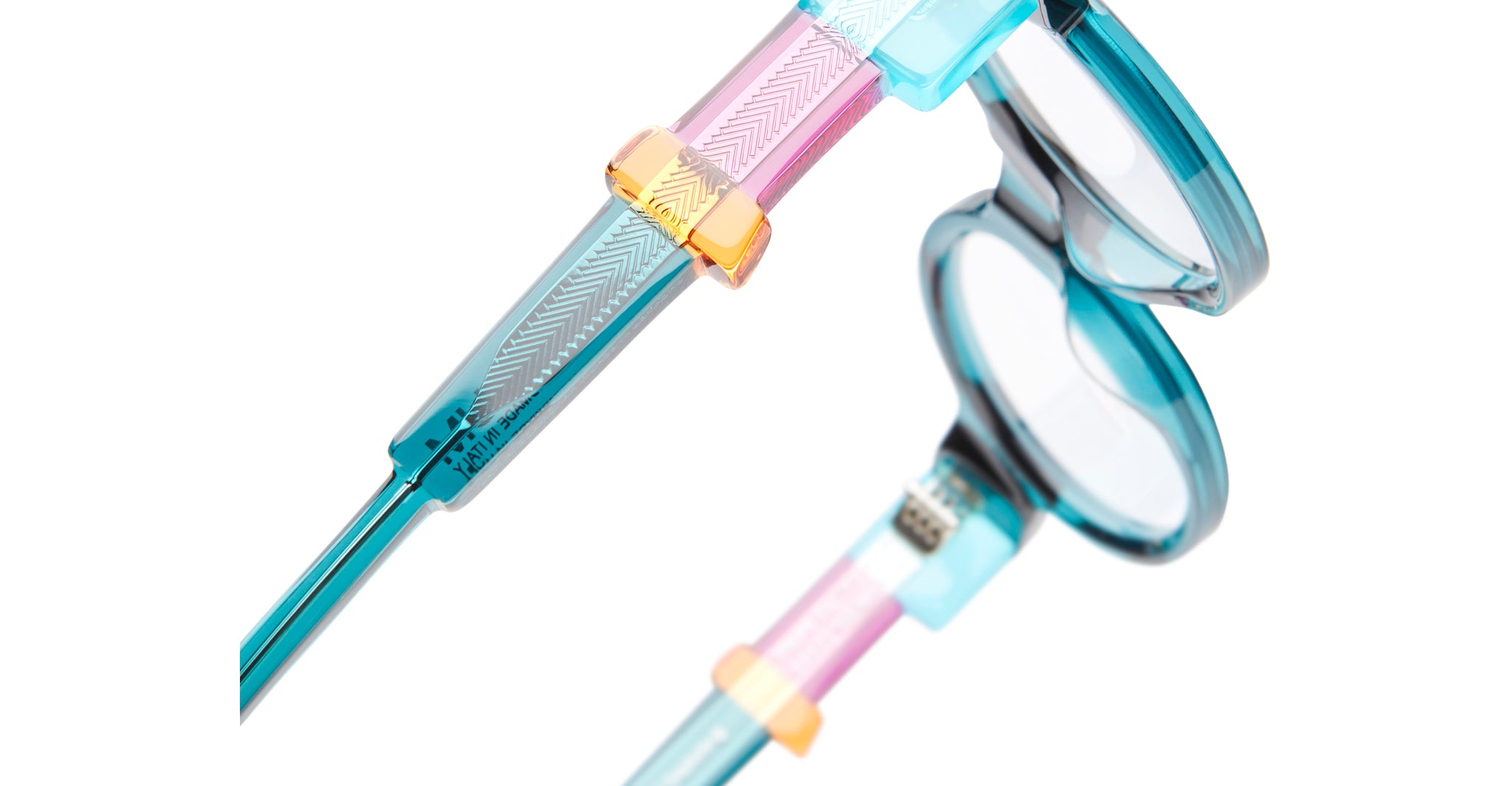 Close-up of KUBORAUM I02 round blue eyeglasses with patterned arms, pink and gold geometric details, front angle.