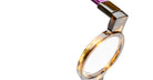 Close-up of KUBORAUM I02 eyeglasses showing amber frame and purple handle, with brand and model details clearly visible.