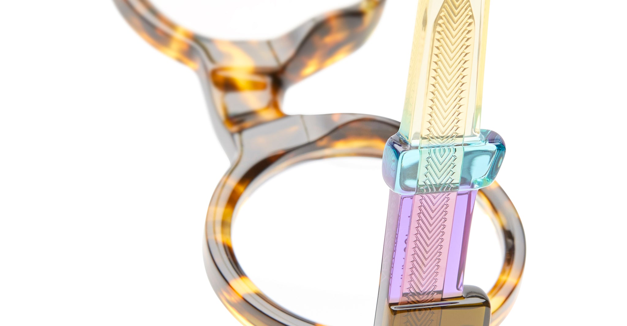 Close-up of KUBORAUM I02 tortoiseshell eyeglasses showing patterned, colorful acetate arms, front angle.