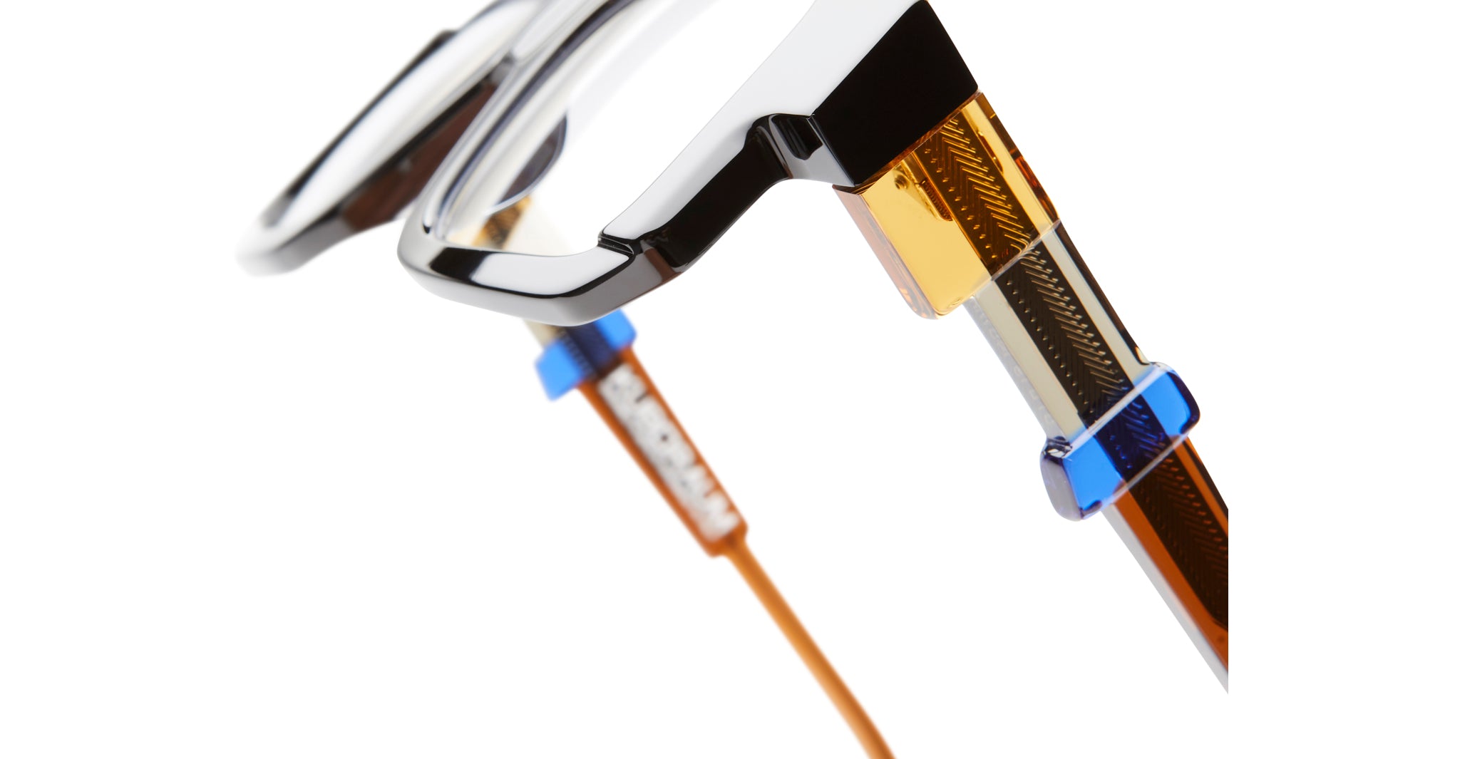 Close-up of KUBORAUM Kuboraum I03 eyeglasses showing a geometric multicolored frame and amber-blue accents on the arms.