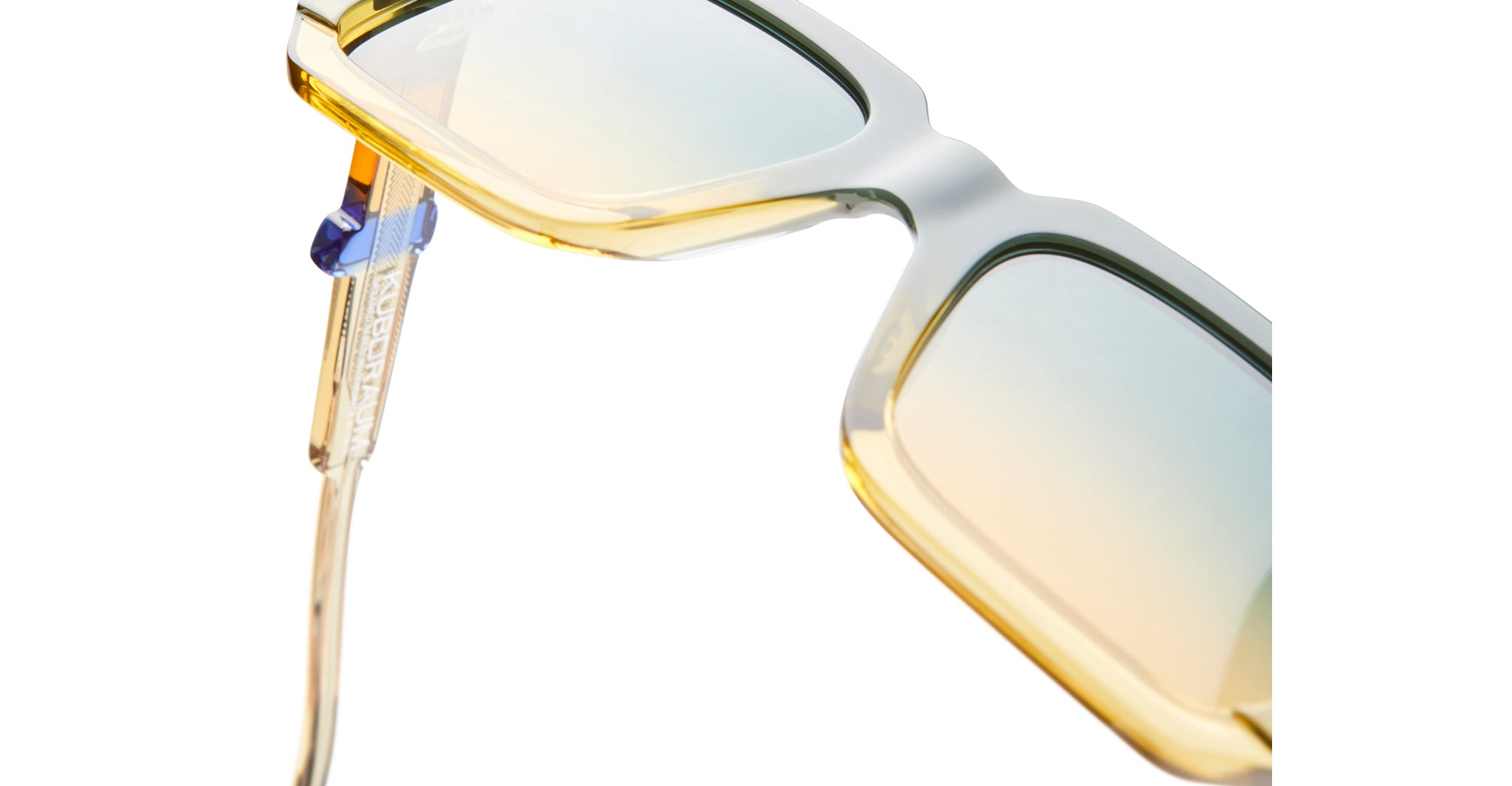 Close-up of KUBORAUM I03 yellow-tinted blue light eyeglasses with transparent frames and logo on the temple.