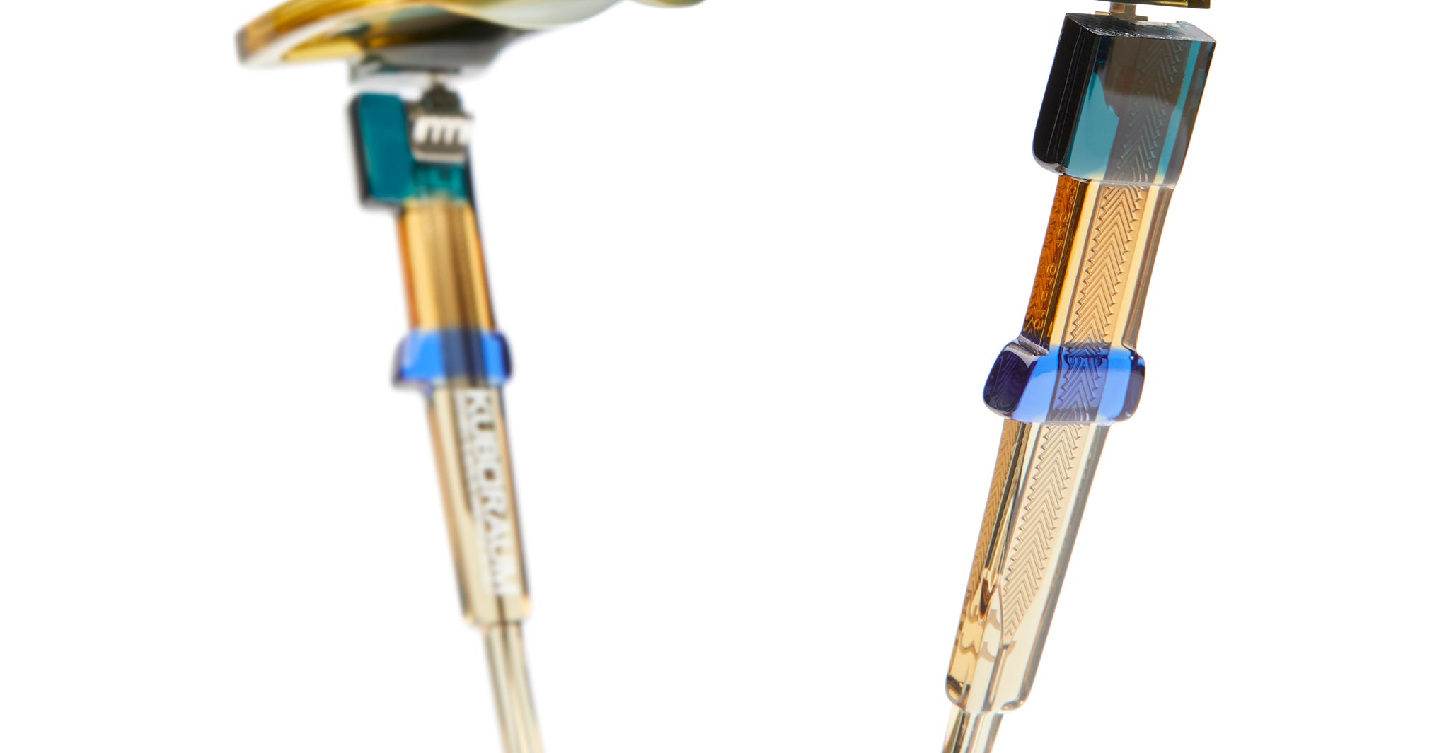 Close-up side view of Kuboraum I03 eyeglasses temples and hinges, showing multicolored metal and acetate details.