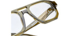 Close-up of transparent olive-green Kuboraum K33 eyeglass frames with clear lenses, highlighting frame details, lens markings, and product info on the inner temple.