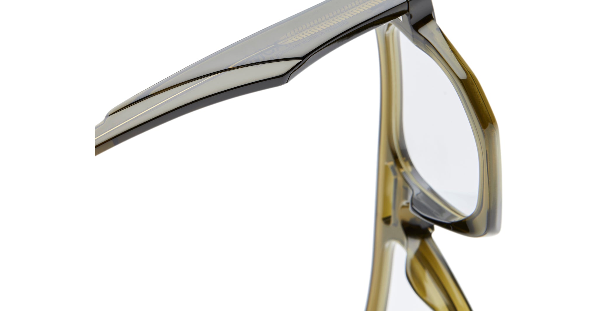 Close-up view of the hinge and arm of Kuboraum K33 eyeglasses with transparent olive green frames, highlighting their smooth, glossy finish and contemporary design details.