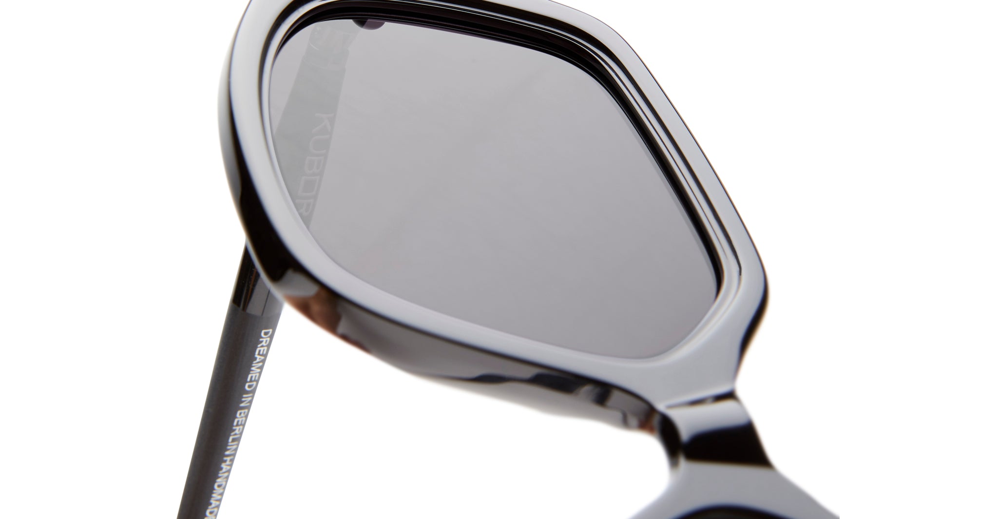 Close-up of KUBORAUM Kuboraum P20 black sunglasses, showing the corner and tinted lenses from a side angle.