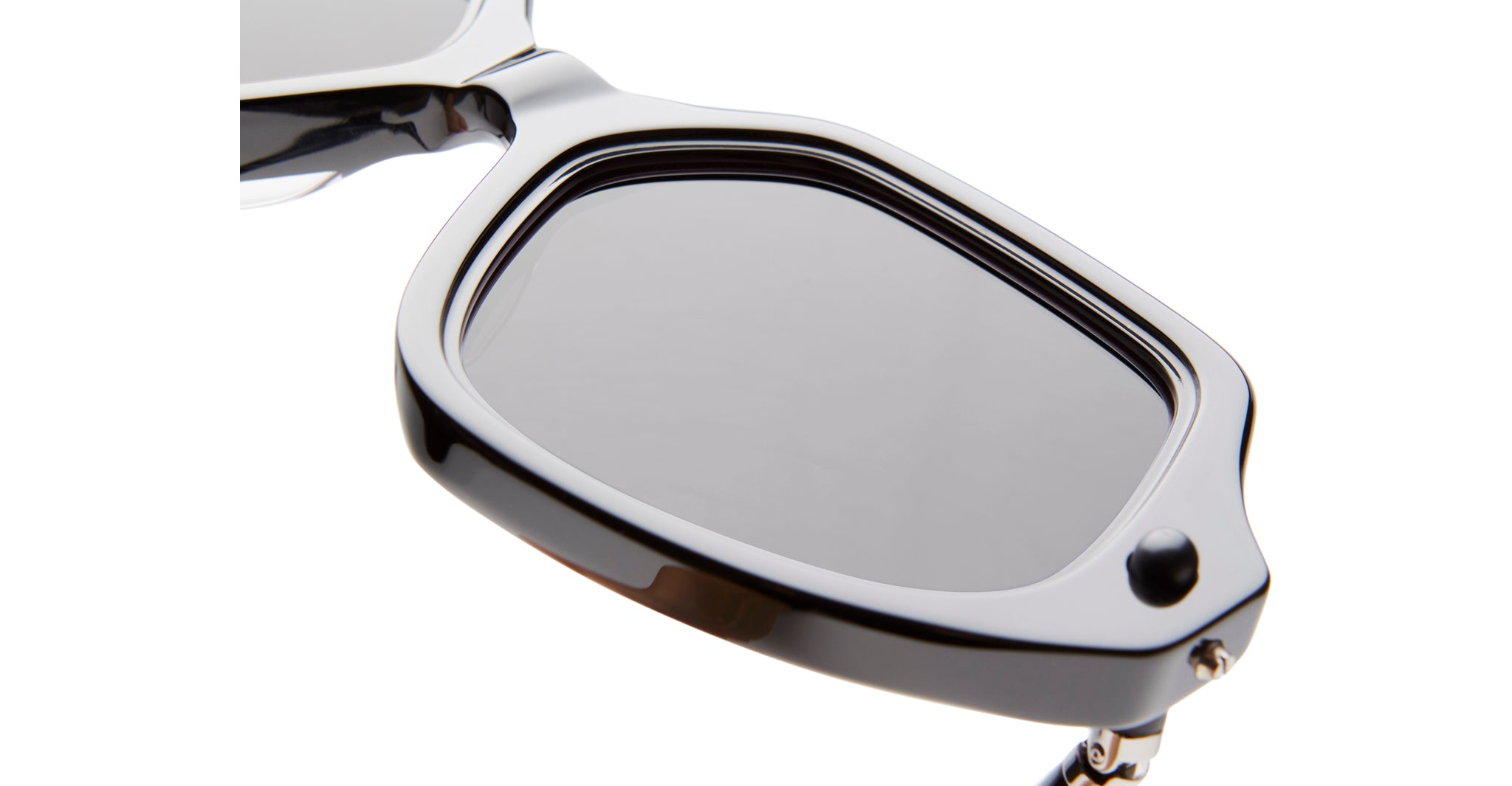 Close-up of KUBORAUM P20 black sunglasses, one lens removed to reveal hinge and frame construction, viewed from the side.