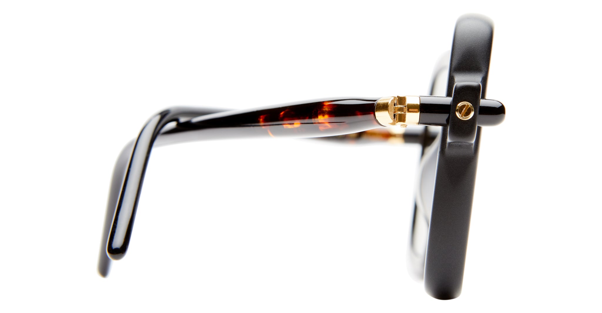 Close-up side view of the Kuboraum P21 eyeglasses, featuring a thick black frame, gold hinge, and tortoiseshell-patterned temple arm against a white background.