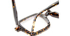 Close-up of Kuboraum P21 tortoiseshell eyeglass frames with rectangular lenses. One arm is folded, the other partially extended, showcasing their glossy, speckled brown and amber pattern against a white background.
