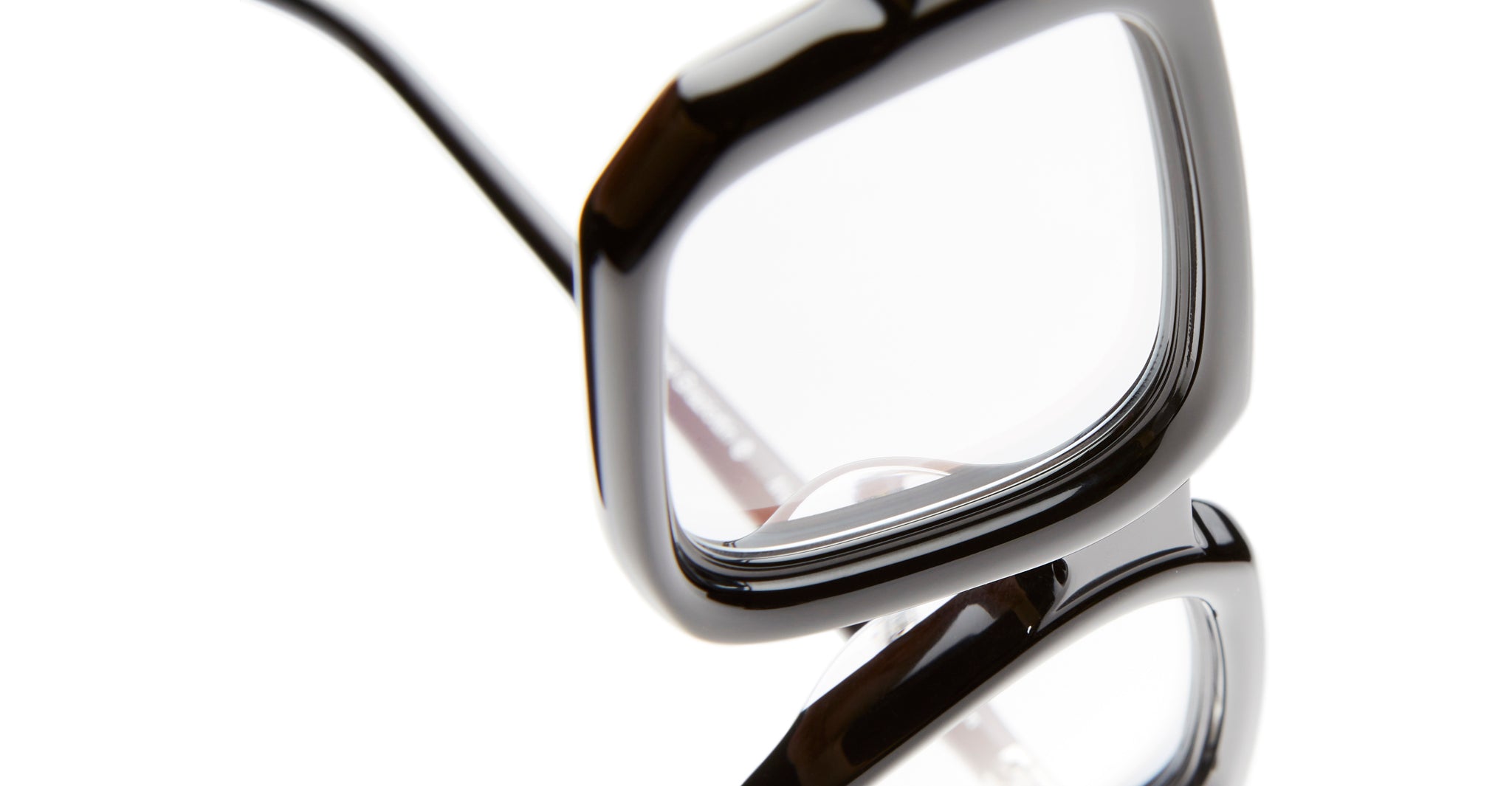 Close-up of Kuboraum P23 black, square-framed eyeglasses against a white background, highlighting the edges of the frames and the clear lenses.