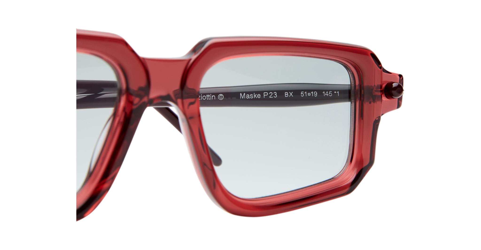 Close-up of the upper corner of Kuboraum P23 red square eyeglass frames with clear lenses. Product details in white text are visible on the inner temple arm against a white background.