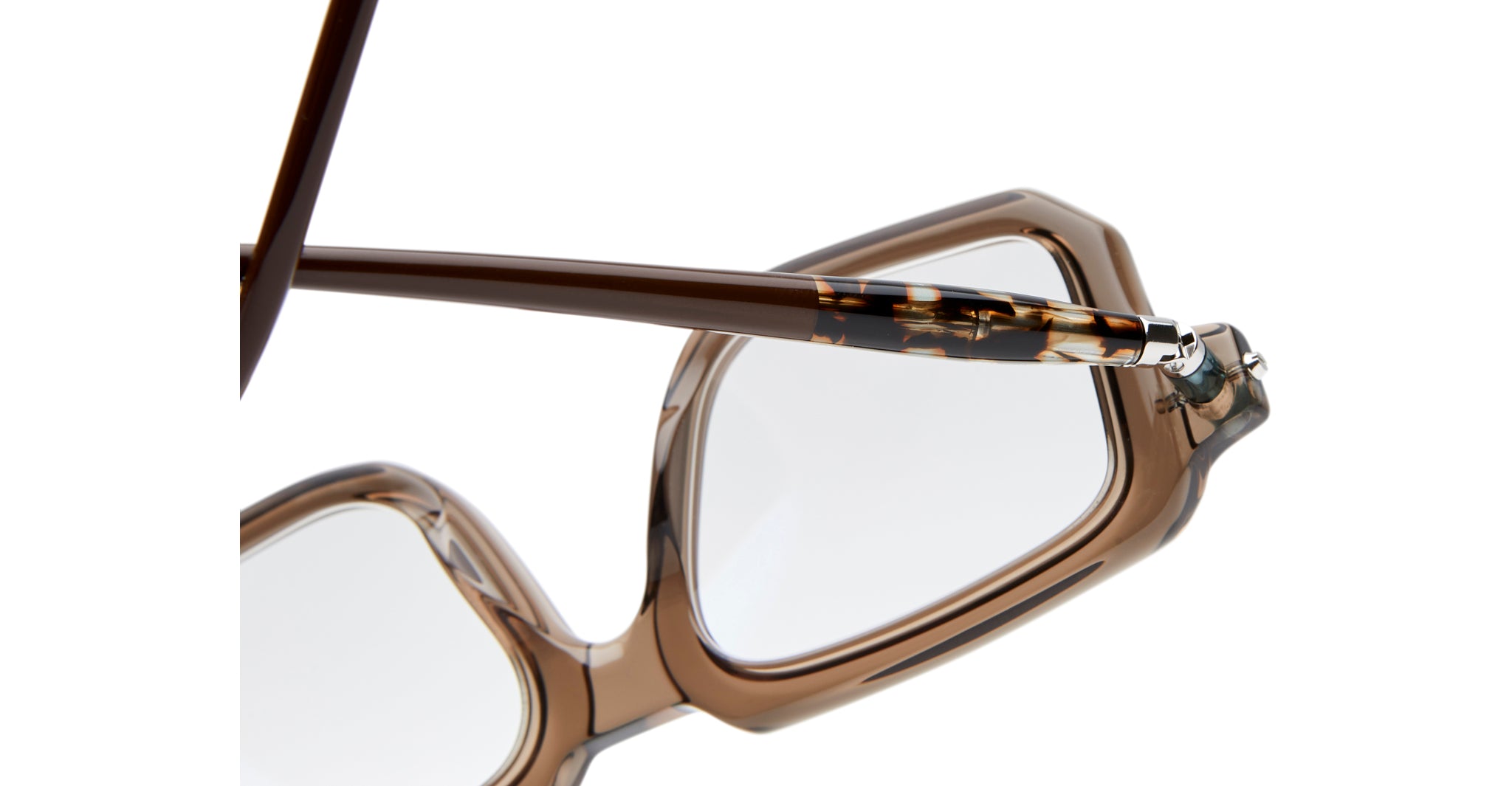 Close-up of Kuboraum P23 translucent brown eyeglass frames with clear lenses and a partially open arm featuring a tortoiseshell pattern against a white background.