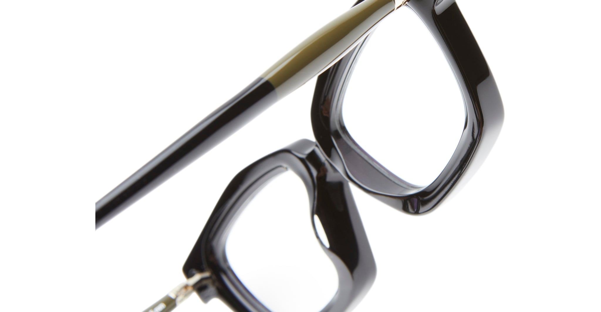 Close-up of the Kuboraum P25 eyeglasses’ black frames and temples against a white background, highlighting the angular lens design and glossy finish.