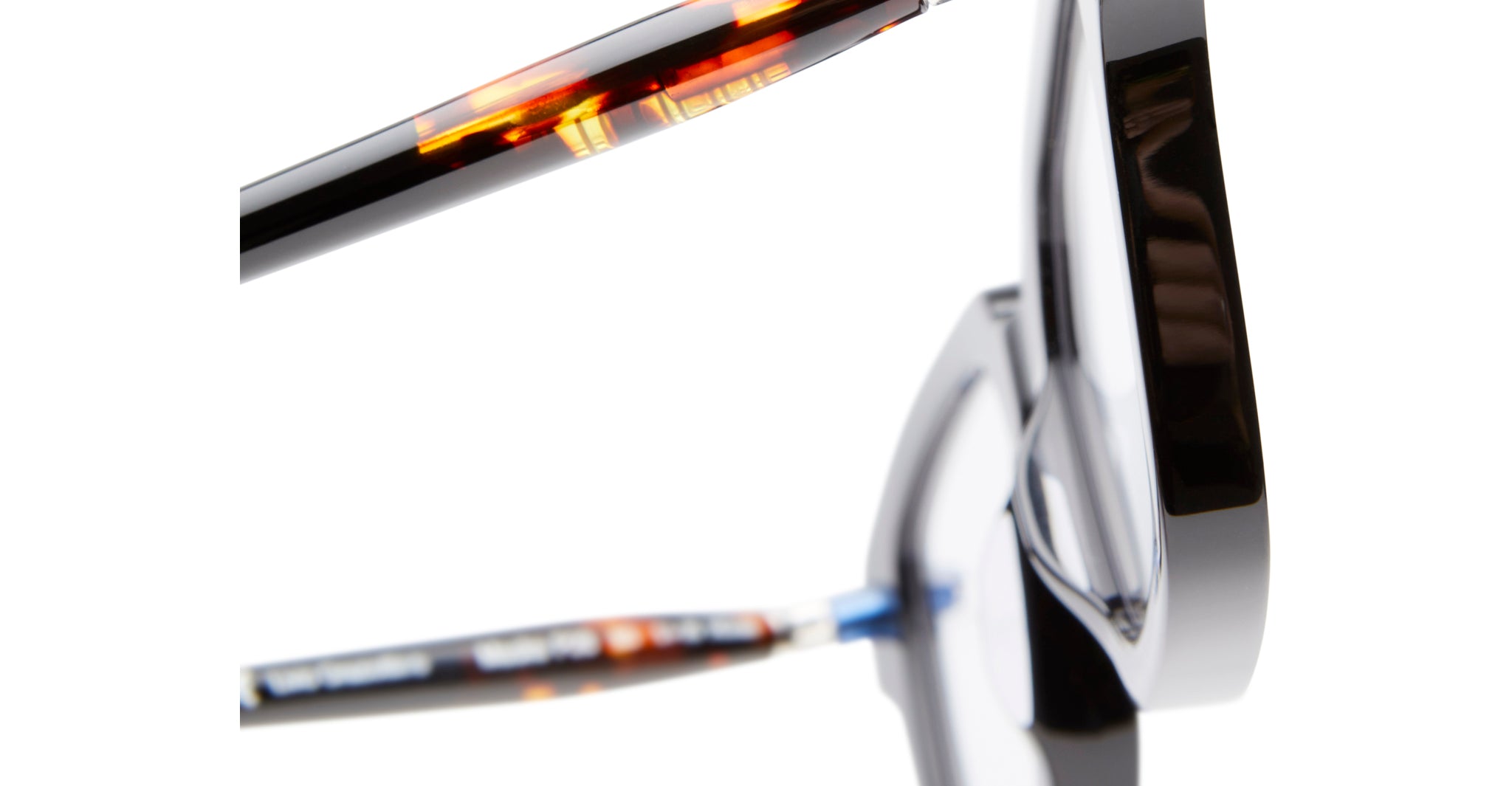 Close-up of KUBORAUM Kuboraum P28 eyeglasses, featuring tortoiseshell and black hinges and arms, viewed from the side.