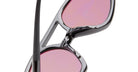 Close-up of KUBORAUM P31 black sunglasses frames with pink lenses, partially folded, showing the modern eyewear design.