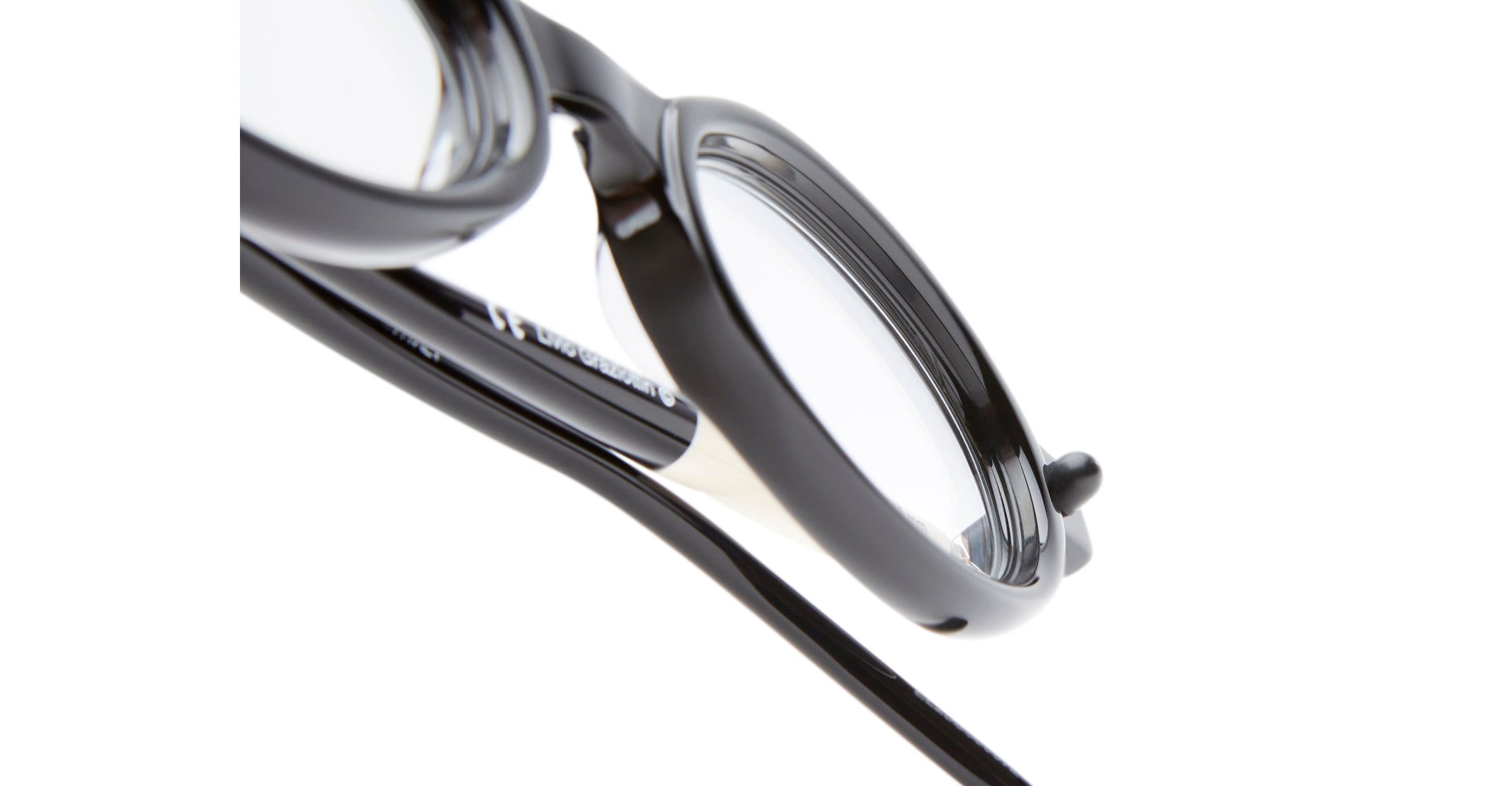 Close-up of Kuboraum P6 black eyeglass frames with clear lenses, highlighting the temple and hinge details against a white background.