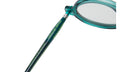 Close-up of the teal-colored arm of a pair of eyeglasses, with the words Hamburger Bahnhof and other text printed in yellow-green along the side. The clear lens and part of the round frame are visible.
