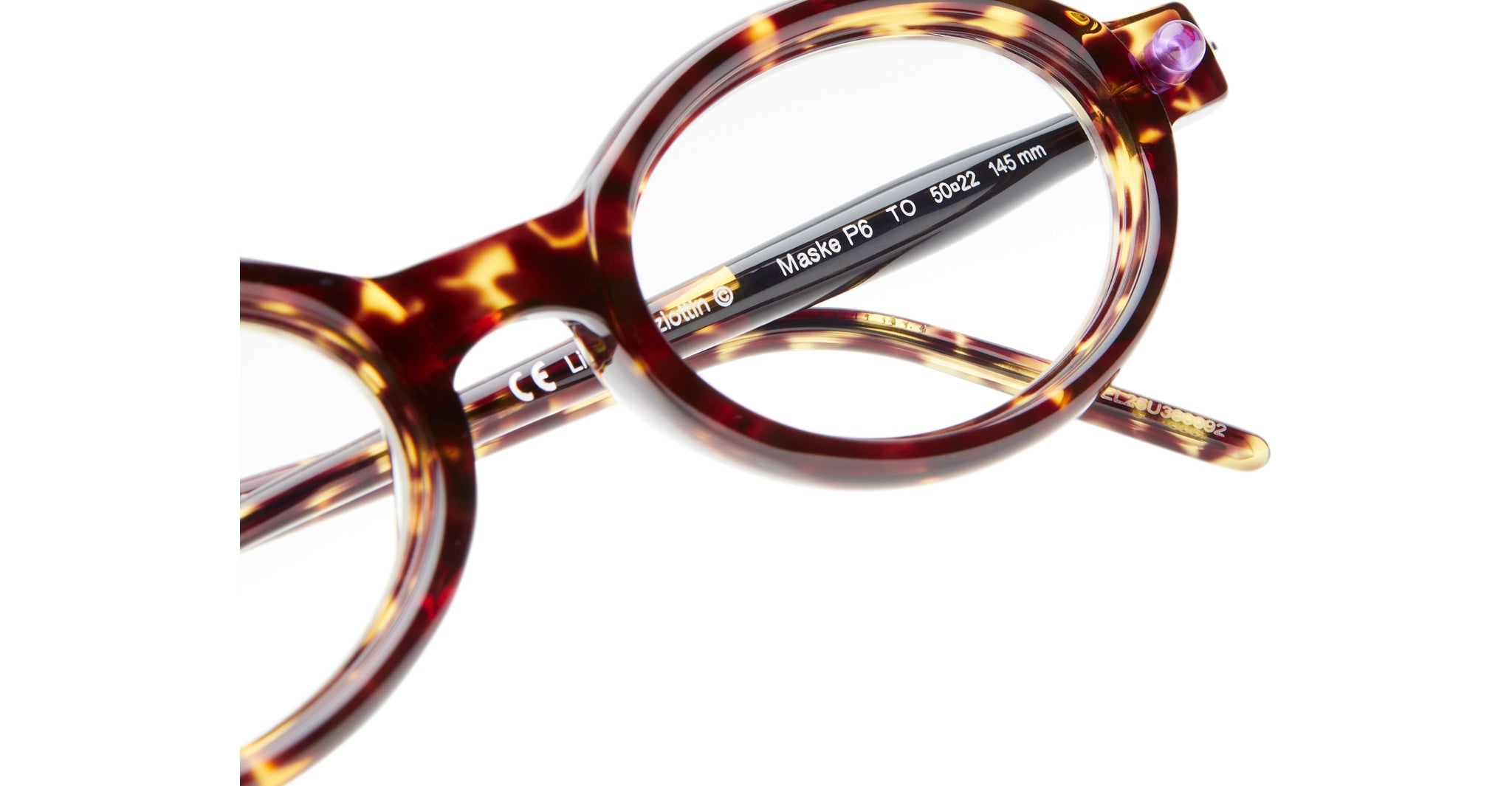 Close-up of Kuboraum P6 round tortoiseshell eyeglasses with brown and amber patterns. Model details and measurements are visible on the inner arm. Set against a white background.