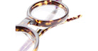 Close-up of Kuboraum P6 round eyeglasses featuring a tortoiseshell pattern with clear lenses and a partial view of the frame and temple set against a white background.
