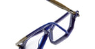 Close-up of Kuboraum P8 stylish blue eyeglasses with transparent lenses, highlighting the nose bridge and part of the temples, set against a white background.