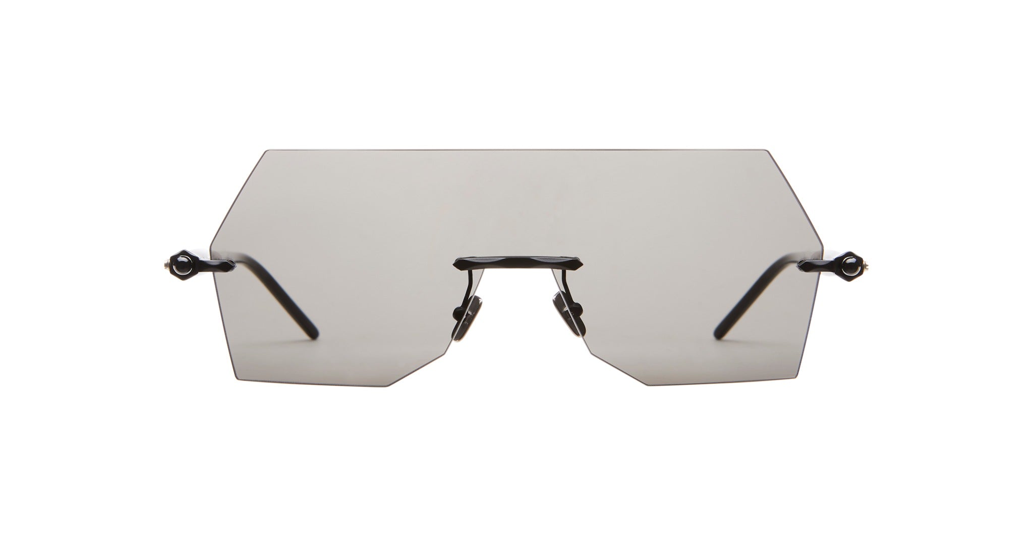 The Kuboraum P90 features a rimless design with large, geometric tinted lenses and thin black arms, shown against a white background.