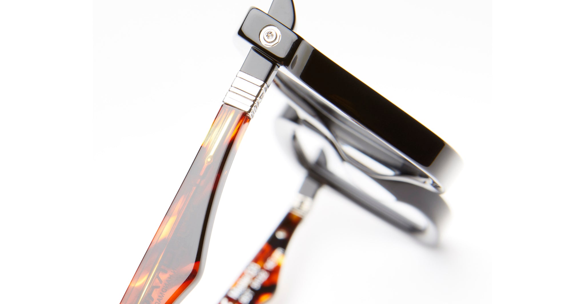 Close-up view of Kuboraum Q3 eyeglasses with black frames and tortoiseshell-patterned arms, displayed from an angled perspective on a white background.