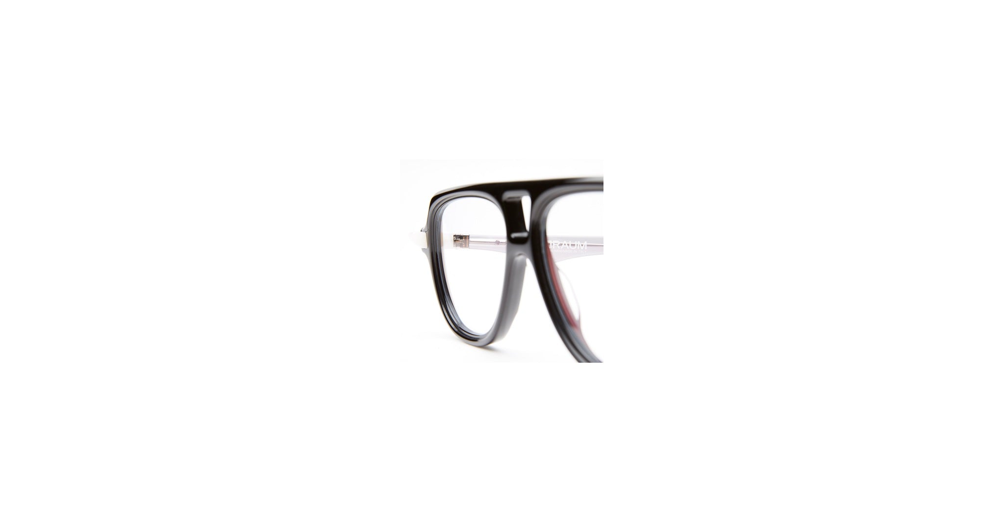 Close-up of the left side of Kuboraum Q4 black eyeglass frames with clear lenses, shown against a white background. Only part of the frames is visible in the image.
