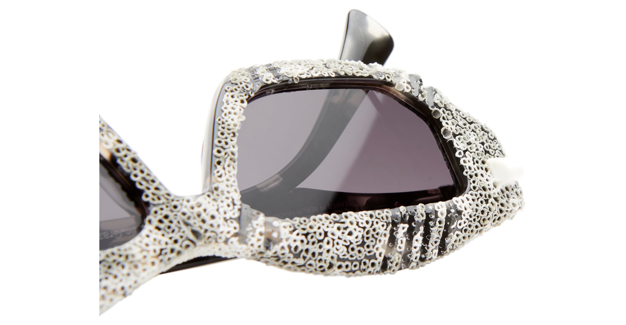 Close-up of Kuboraum Q6 sunglasses featuring thick, textured frames in white and gray with a coral-like design and dark tinted lenses—showcasing an organic, distinctive look.