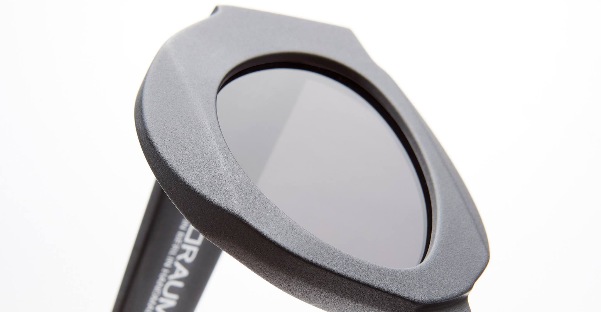 Close-up of Kuboraum X22 black sunglasses featuring a thick, geometric frame and dark lenses against a white background. The Kuboraum branding is partially visible on the arm.