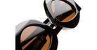 Close-up of black KUBORAUM X22 sunglasses featuring brown tinted lenses, showing the front view of the eyewear.