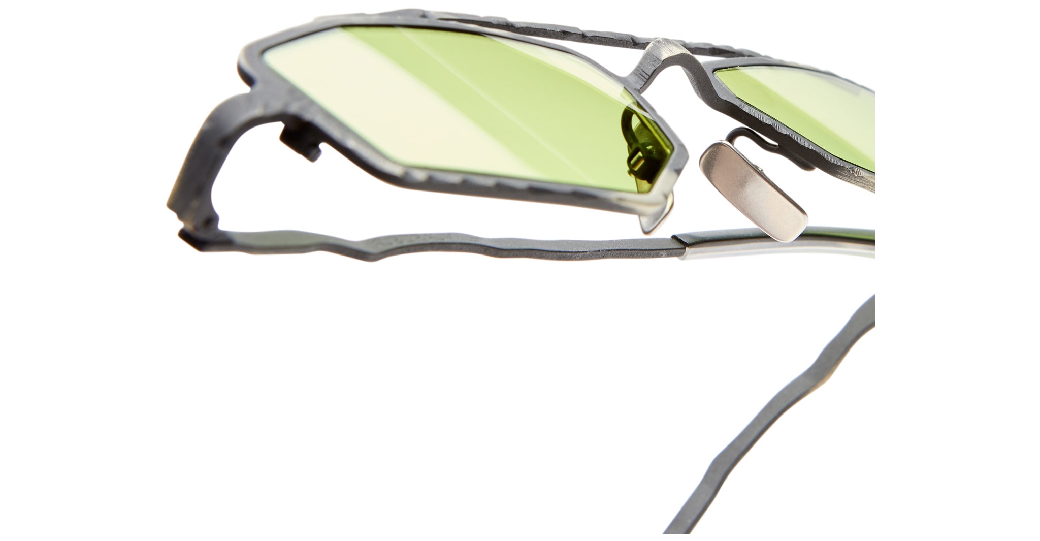 Close-up of Kuboraum Z23 sunglasses featuring angular, irregular black frames and light green-tinted lenses, photographed against a white background.