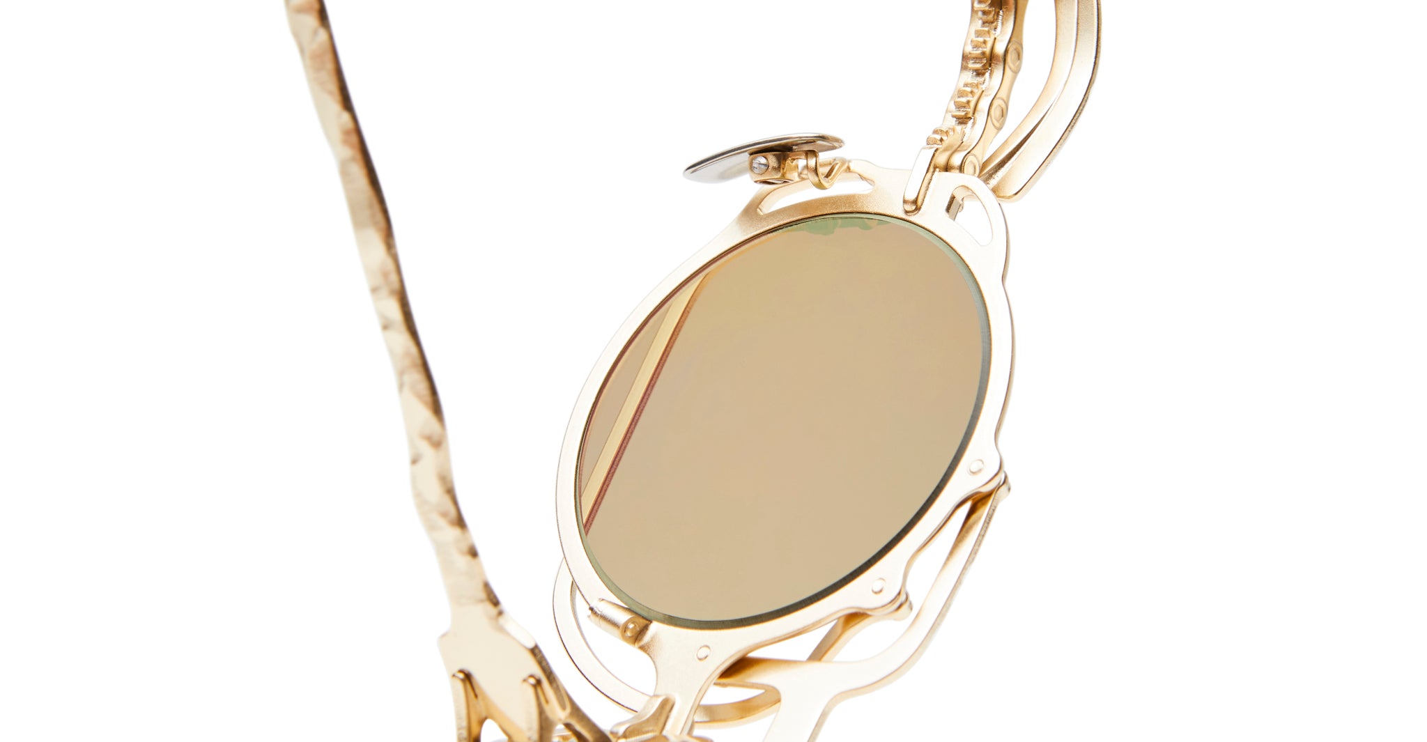 Close-up of KUBORAUM Z50 gold monocle eyeglasses with ornate detailing and a neutral-tinted lens.