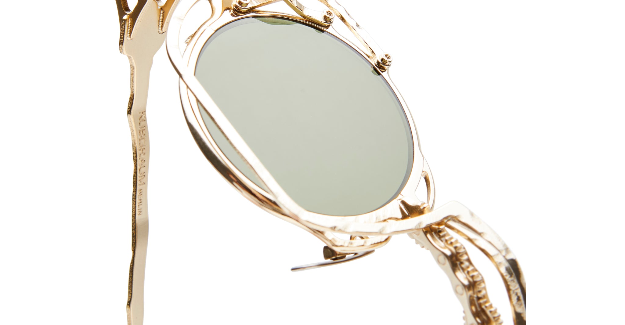 Close-up of Kuboraum Z50 gold sunglasses by KUBORAUM, featuring a sculpted frame and green oval lenses, front view.